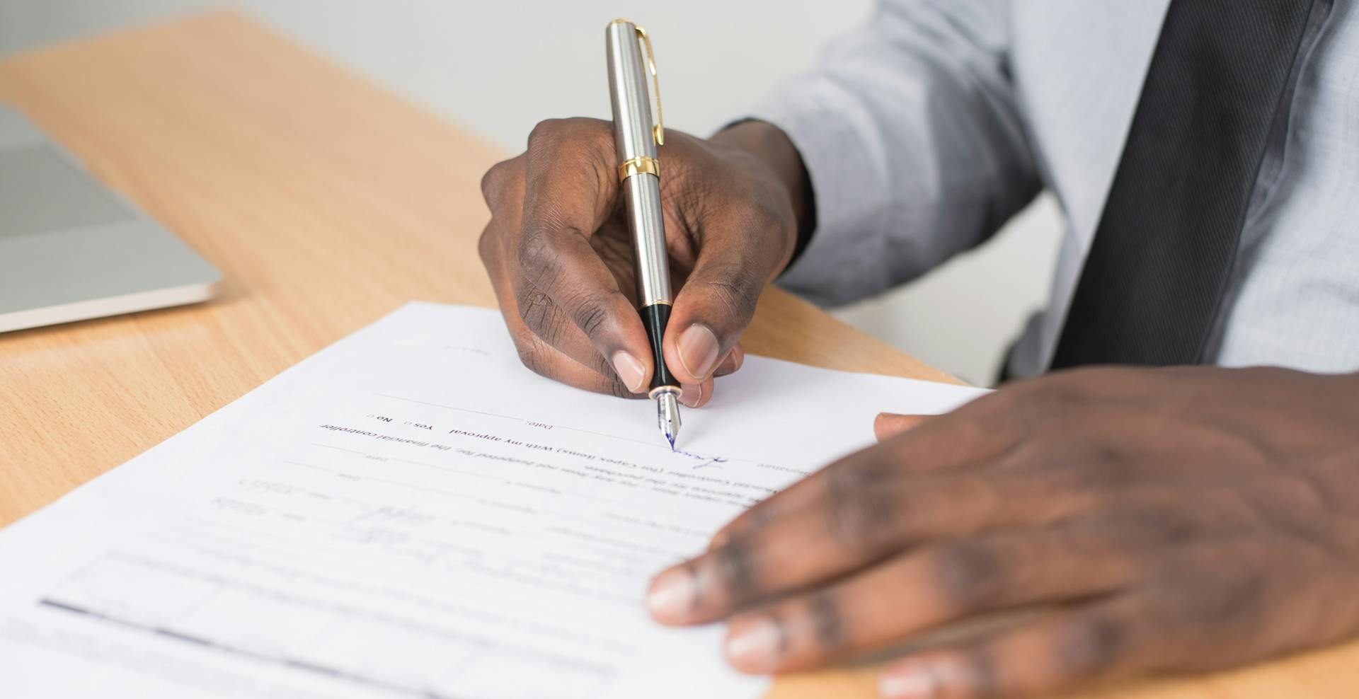 man signing employment contract